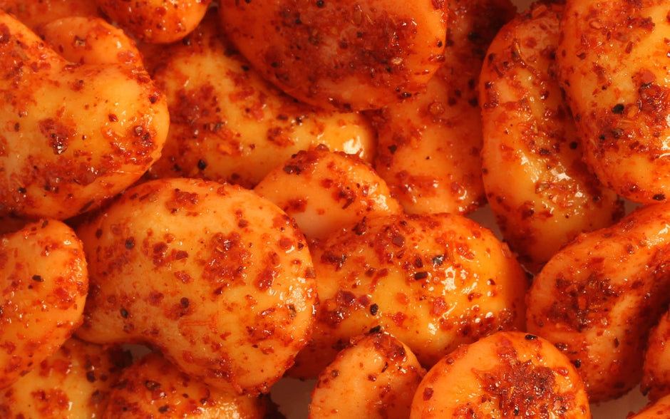 Close-up of Spicy Mango Gummies coated in chili seasoning and chamoy